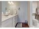 Bathroom with double sink vanity with a white marble countertop, sleek fixtures, and hardwood floors at 1510 Dominion Dr, Zionsville, IN 46077