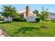 A sprawling green lawn surrounds the rear of this home featuring mature trees and a white picket fence at 1510 Dominion Dr, Zionsville, IN 46077