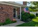 A welcoming front porch with an American flag, brick facade, and blooming flowers at 1510 Dominion Dr, Zionsville, IN 46077