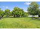 Large grass backyard with mature trees and black fencing at 15515 Alameda Pl, Westfield, IN 46074