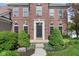 Close-up of the brick facade featuring a stylish front door flanked by manicured shrubs at 15515 Alameda Pl, Westfield, IN 46074