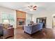 Comfortable living room with a brick fireplace, ceiling fan, and hardwood floors at 15515 Alameda Pl, Westfield, IN 46074