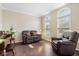 Cozy living room featuring hardwood floors, a leather loveseat, and natural light at 15515 Alameda Pl, Westfield, IN 46074