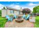 Landscaped backyard featuring an outdoor patio, fire pit, and comfortable seating under blue sky at 1630 Eastfork Dr, Brownsburg, IN 46112