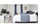 Inviting bedroom featuring a large bed with a striped blanket, black-out curtains, and modern decor at 1630 Eastfork Dr, Brownsburg, IN 46112