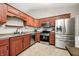 Bright kitchen showcasing cherry cabinets, modern appliances, and easy-to-clean tile floors at 1630 Eastfork Dr, Brownsburg, IN 46112