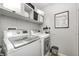 Clean laundry room featuring front load washer and dryer with white cabinets above at 1630 Eastfork Dr, Brownsburg, IN 46112