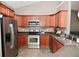 A kitchen featuring wooden cabinets, stainless steel appliances, and tile flooring at 1635 N College Ave # 4, Indianapolis, IN 46202