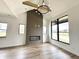 Open-concept living room featuring hardwood floors, large windows, fireplace with wooden beam, and modern lighting fixture at 1663 Fernley Dr, Westfield, IN 46074
