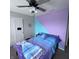 Bright bedroom features neutral walls, carpeting, a ceiling fan, and colorfully painted accent wall at 1721 N Kaleigh Ln, Greensburg, IN 47240
