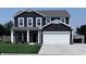 Charming two-story home with a well-manicured lawn, a covered porch, and a two-car garage at 1721 N Kaleigh Ln, Greensburg, IN 47240