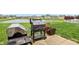 Spacious backyard with a grill, lush greenery, and a pond in the background, perfect for outdoor activities at 1893 Devonshire Ave, Avon, IN 46123