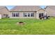 A view of the backyard with a fire pit, grill, and sliding glass door to the home at 1893 Devonshire Ave, Avon, IN 46123