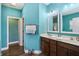 Bathroom featuring dual sinks, a walk-in closet, and stylish teal walls at 1893 Devonshire Ave, Avon, IN 46123