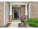 Inviting front porch with brick columns, flower arrangements and a decorative wreath at 1893 Devonshire Ave, Avon, IN 46123