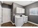 Well-equipped laundry room with modern washer, dryer, and ample storage cabinets at 1893 Devonshire Ave, Avon, IN 46123