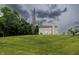 Expansive backyard view with lush green lawn, mature trees, and the home's exterior with sliding glass doors at 19187 Outer Bank Rd, Noblesville, IN 46062