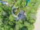 A bird's-eye view showcases a beautiful home with a serene pond, lush greenery, and a private driveway at 2004 Layton Rd, Anderson, IN 46011