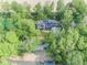 Stunning aerial view of a home nestled among lush trees with a private drive and a glimpse of a tranquil pond at 2004 Layton Rd, Anderson, IN 46011