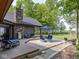 Backyard featuring a patio with outdoor seating, stone accents, and lush trees at 2004 Layton Rd, Anderson, IN 46011