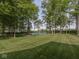 Expansive backyard featuring mature trees, a lush lawn, and a serene pond for ultimate relaxation at 2004 Layton Rd, Anderson, IN 46011