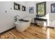 Bright bathroom featuring a freestanding tub, accent lighting, wooden floors, and framed windows at 2004 Layton Rd, Anderson, IN 46011