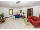 Bright bedroom featuring soft carpet, white walls, and complemented by a comfortable red leather sofa at 2004 Layton Rd, Anderson, IN 46011
