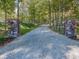 Long driveway leading to the house, flanked by stone pillars and colorful flower planters at 2004 Layton Rd, Anderson, IN 46011