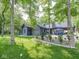 Stunning exterior view of home with a stone chimney, outdoor seating, and lush landscaping at 2004 Layton Rd, Anderson, IN 46011
