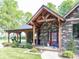 Charming home featuring a covered porch, stone accents, and beautiful landscaping at 2004 Layton Rd, Anderson, IN 46011