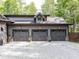 Spacious three-car garage with gray doors and stone accents, perfect for car enthusiasts at 2004 Layton Rd, Anderson, IN 46011