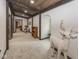 Well-lit hallway with carpet, wooden accents, and open doorways leading to other rooms in the home at 2004 Layton Rd, Anderson, IN 46011