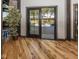 Living room featuring hardwood flooring, a decorative indoor tree, and bright patio access at 2004 Layton Rd, Anderson, IN 46011
