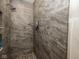 Stylish shower stall featuring gray-toned marble walls, and pebble stone flooring at 2004 Layton Rd, Anderson, IN 46011