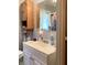 Bathroom featuring a white vanity with storage, decorative mirror, and wood-look storage cabinet at 2032 N Auburn St, Speedway, IN 46224