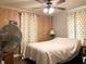 Bedroom displaying paneled walls, a ceiling fan, and hardwood-look flooring throughout at 2032 N Auburn St, Speedway, IN 46224