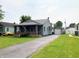 Exterior view of a quaint home with a detached garage and a long driveway at 2032 N Auburn St, Speedway, IN 46224