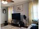 Comfortable living room with a ceiling fan, television, and decorative curtains at 2032 N Auburn St, Speedway, IN 46224