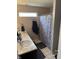 Bathroom featuring double sinks, neutral paint, tile floor and seashell shower curtain at 2302 Rolling Oak Dr, Indianapolis, IN 46214