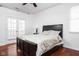 Comfortable bedroom with a queen size bed, bedside lamp and hardwood flooring at 2326 N Pennsylvania St # 6, Indianapolis, IN 46205