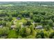 Aerial view shows the surrounding lush green tree landscape and quaint neighborhood at 233 Saddlebrook Dr, Zionsville, IN 46077