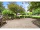 Spacious backyard featuring a brick patio, privacy fence, and mature trees, creating a serene outdoor living space at 233 Saddlebrook Dr, Zionsville, IN 46077