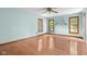 Spacious bedroom features gleaming hardwood floors, fresh paint, and light from large windows at 233 Saddlebrook Dr, Zionsville, IN 46077