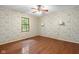 Bright bedroom with hardwood floors features natural light from the large window and decorative wallpaper at 233 Saddlebrook Dr, Zionsville, IN 46077