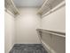 Walk-in closet with black tiled floors and wooden closet rods and shelves at 233 Saddlebrook Dr, Zionsville, IN 46077