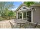 A wooden deck features outdoor seating and sliding doors leading into the house and treed backyard at 233 Saddlebrook Dr, Zionsville, IN 46077