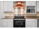 Close-up of the kitchen featuring stainless steel oven, microwave, and vent hood at 233 Saddlebrook Dr, Zionsville, IN 46077