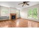 Living room with fireplace, hardwood floors, many windows for light, and a ceiling fan at 233 Saddlebrook Dr, Zionsville, IN 46077