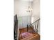 Well-lit stairwell features a patterned rug and an ornate chandelier at 233 Saddlebrook Dr, Zionsville, IN 46077