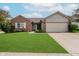 Charming brick home features a manicured lawn, attached garage, and inviting light blue front door at 293 E Quail Wood Ln, Westfield, IN 46074